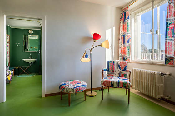 The foyer leading to the guest rooms features a surprising seating ensemble designed by Josef Frank, upholstered in his “Manhattan” fabric design.