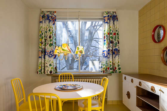 The breakfast room is decorated in yellow and features Josef Frank's “Italian Dinner” fabric.